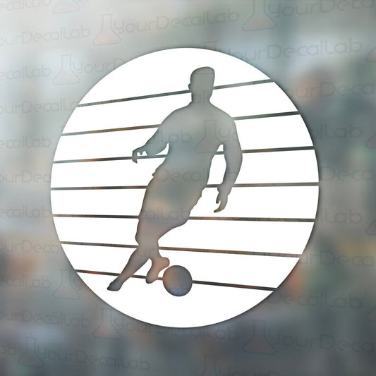 a silhouette of a man kicking a soccer ball