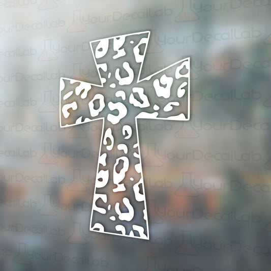 a cross made out of paper on a window