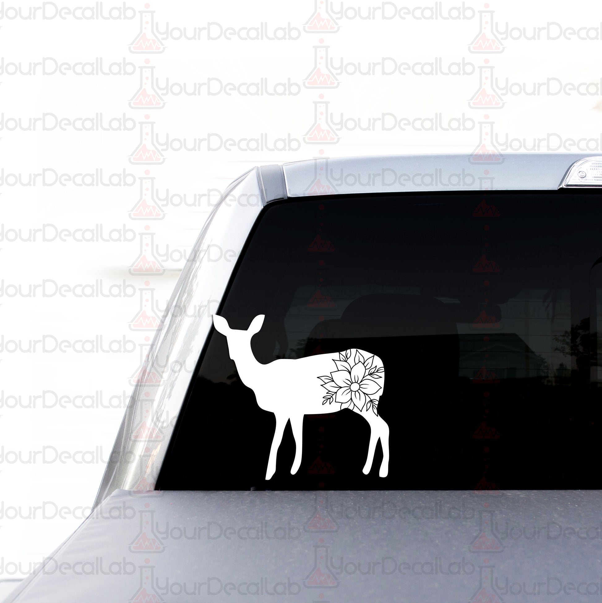 a white deer with a flower in its antlers decal
